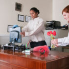 Two cleaning staff members cleaning an office. One is in training